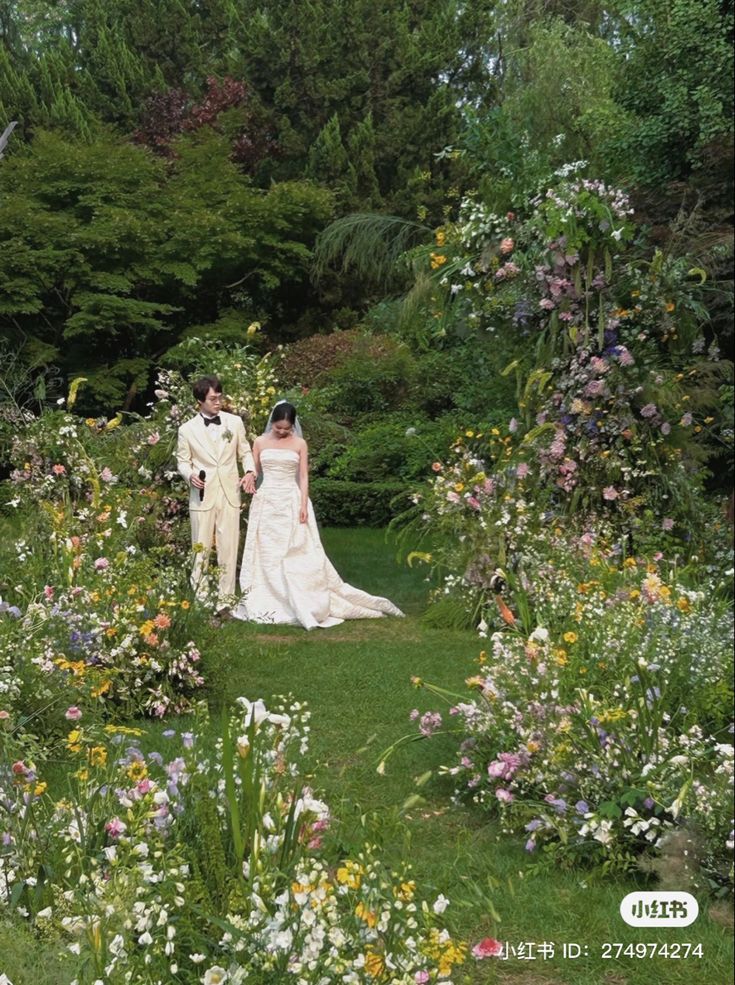 a bride and groom walking through a garden