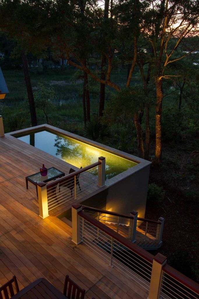 an outdoor pool with lights on the deck