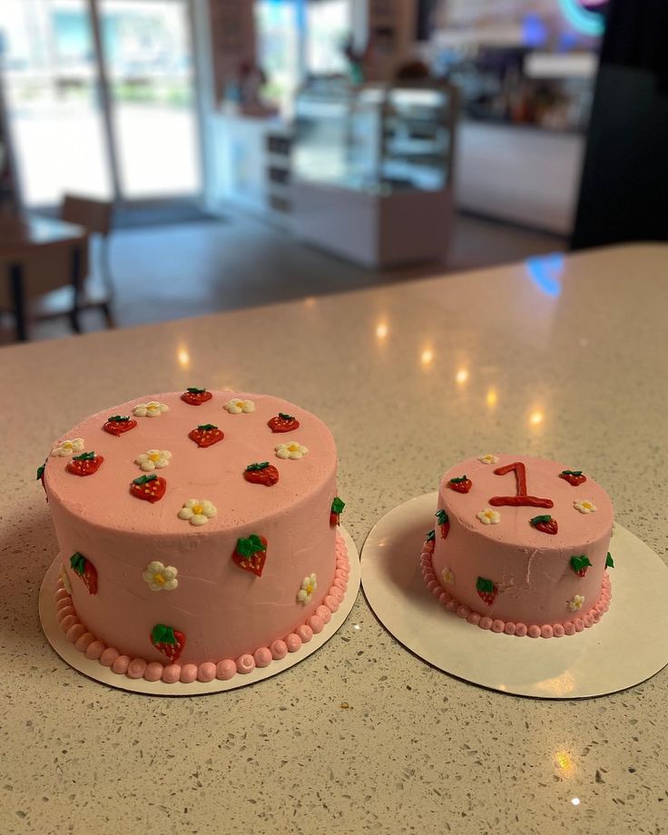 two pink cakes sitting on top of a counter