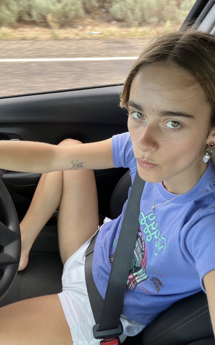 a woman sitting in the driver's seat of a car