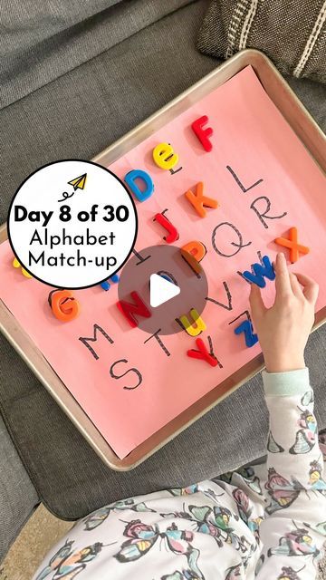 a child is playing with magnets on a pink board that says day 8 of 30 alphabet match - up