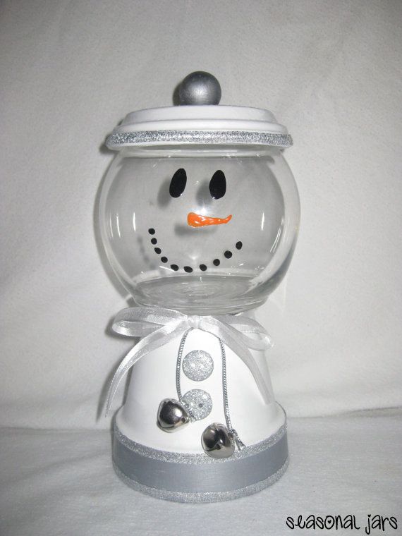 a glass snowman with an orange nose and black eyes