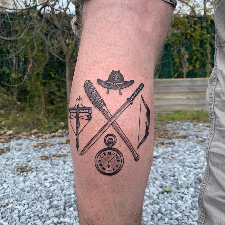 a man's leg with tattoos on it and an arrow, compass, pocket watch