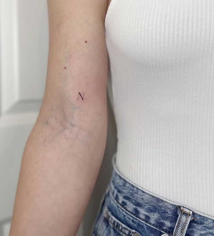 a woman's arm with a small tattoo on the left side of her arm