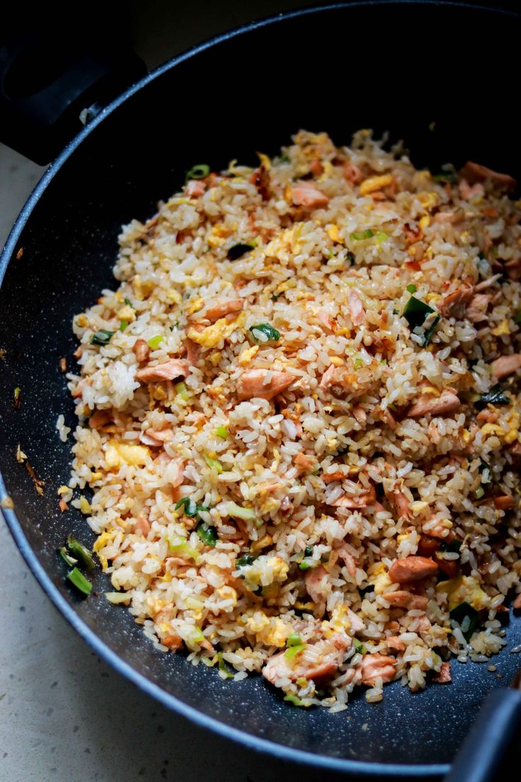 a pan filled with rice and vegetables on top of a table