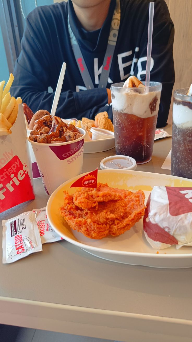 a man sitting at a table in front of some food and drinks on the table