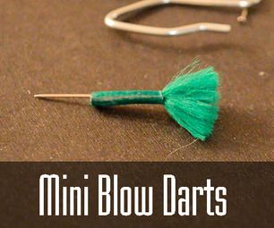 a pair of scissors and some yarn on a table with the words mini blow darts