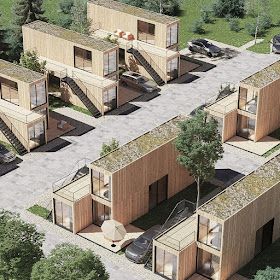 an aerial view of several wooden buildings with cars parked in the driveway and trees around them