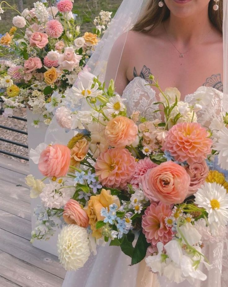 a woman holding a bouquet of flowers in front of her face on a wooden bench