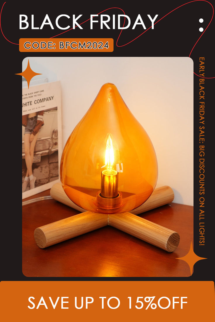 a candle is sitting on top of a table with two wooden sticks and a book