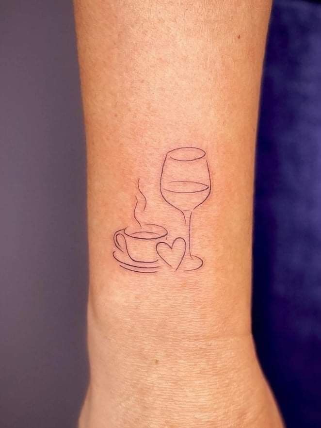 a small tattoo on the wrist of a woman with a cup and saucer in it