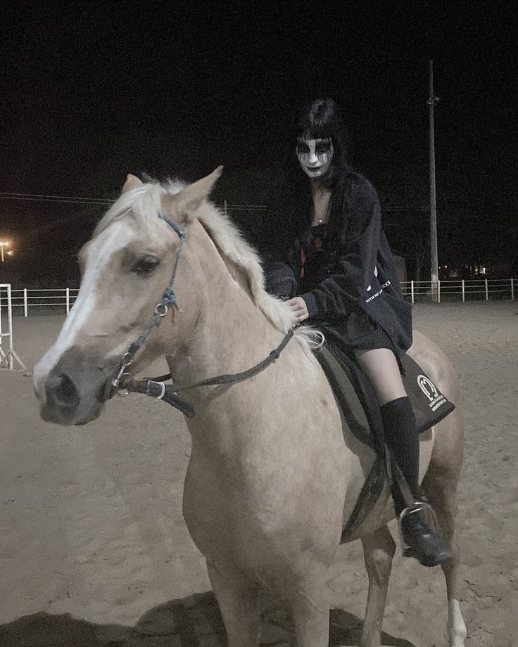 a woman with makeup sitting on top of a white horse