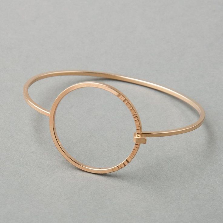 A high-polish bangle made with square wire bands, featuring a circular closure with a hammered texture one third of the way around. - Tension-connection closure- Circle measures 1 ¼” wide- 2mm thick bandSequence Collection Modern Hammered Bangle Bracelets, Modern Hammered Yellow Gold Bracelets, Minimalist Round Hammered Bracelet, Modern Hammered Metal Bracelets, Modern 14k Gold Hoop Bracelets, Modern 14k Gold Hoop Bangle, Modern Rose Gold Bangle, Modern Rose Gold Round Bangle, Modern Hammered Bangle For Formal Occasions