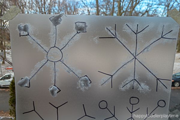 a frosted glass sign with snowflakes on it and trees in the background