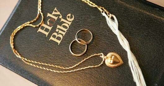 a book with two wedding rings and a tassel hanging from it's cover