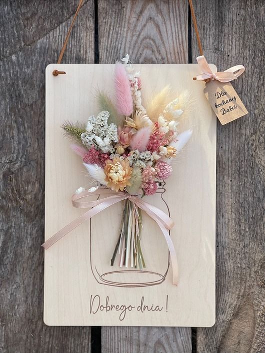 a wooden sign with flowers hanging from it