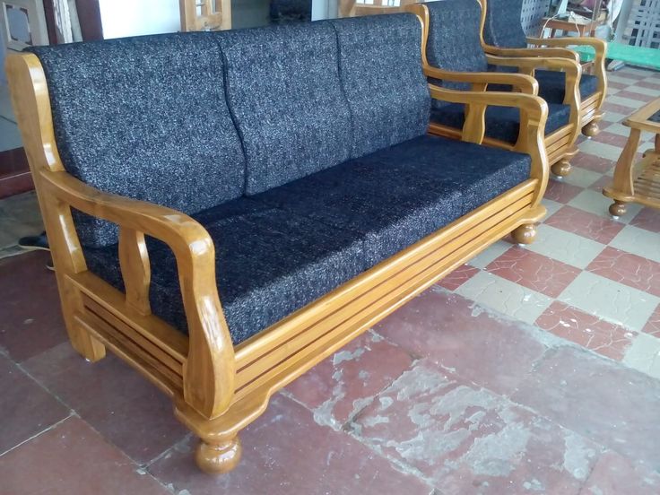 a wooden couch sitting on top of a tiled floor