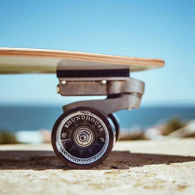 a skateboard is sitting on the ground next to the ocean and blue sky in the background