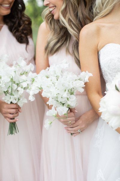 the bridesmaids are all wearing pink dresses and holding bouquets with white flowers