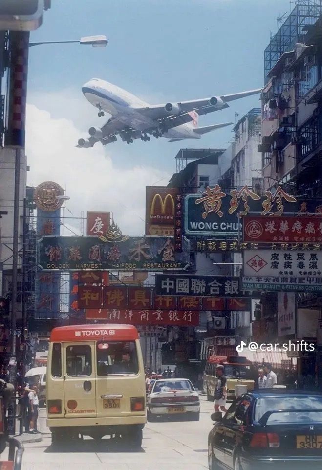 an airplane flying over a busy city street