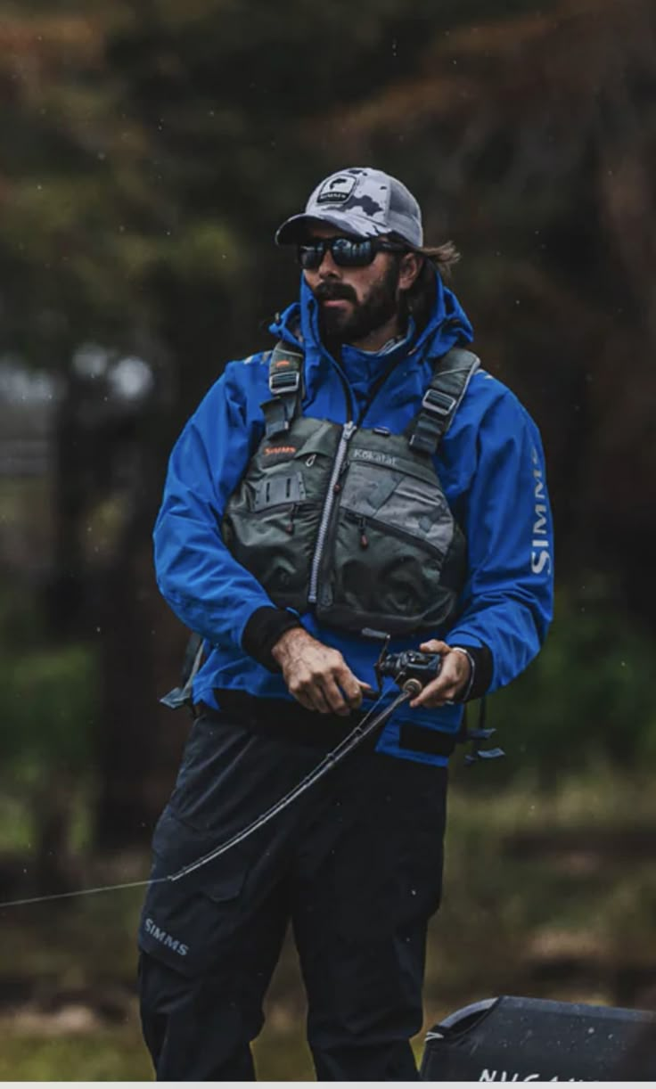 a man in blue jacket holding a fishing rod