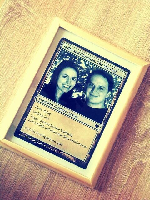 two people are shown on a card in a wooden frame with wood grained flooring