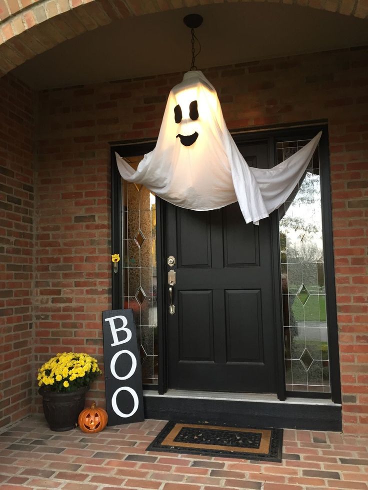 a door with a ghost hanging from it's side and a boo sign on the front