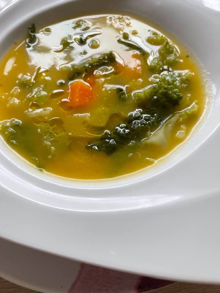 a white bowl filled with soup and vegetables