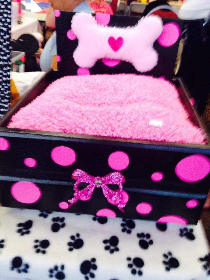 a dog bed with pink and black polka dots on the bottom is decorated with a bow