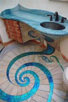 a bathroom with a sink, toilet and mosaic tile flooring on the ground in an artistic manner