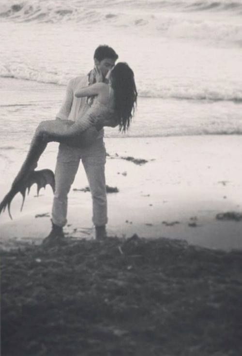 a man carrying a woman on his back at the beach