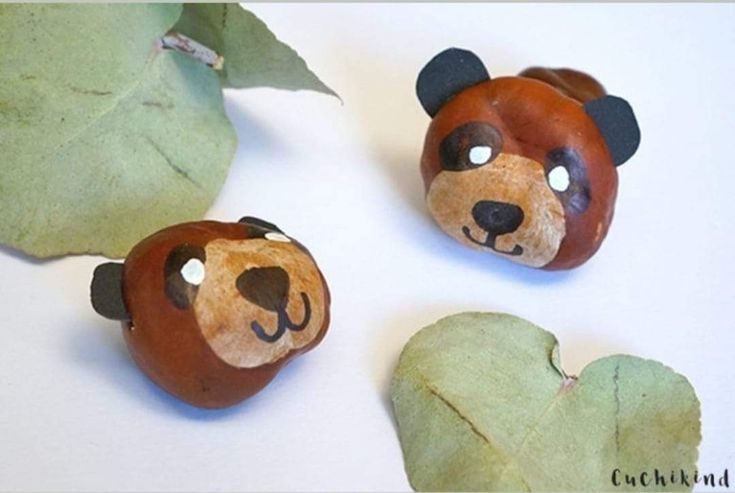 three little bears made out of clay sitting next to each other on top of leaves