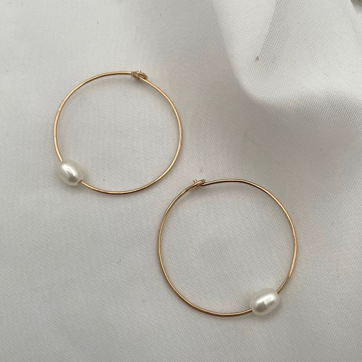 Hand-forged hoops featuring a single freshwater pearl are the perfect everyday accessory. Simple, clean, classic lines you'll never want to take off. Hand-made in our studio. These super lightweight hoop earrings are made of sterling silver or 14kt gold fill wire. Approximately 1 1/4 inch diameter. Minimalist Round Pearl Earrings, Minimalist Hoop Pearl Charm Jewelry, Minimalist Hoop Jewelry With Pearl Charm, Minimalist 14k Gold-filled Hoop Earrings With Pearl Charm, Minimalist 14k Gold Filled Small Hoop Pearl Earrings, Small Pearl Hoop Earrings For Everyday, Minimalist Everyday Hoop Pearl Earrings, Everyday Small Pearl Hoop Earrings, Minimalist Hoop Pearl Earrings With Ear Wire