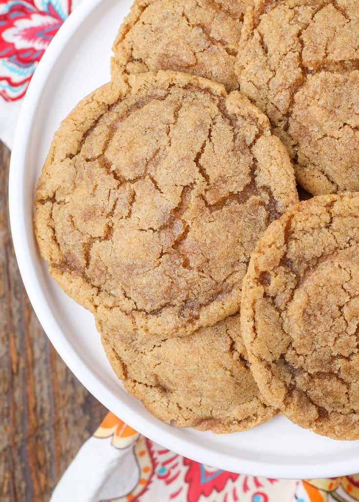 a white plate topped with cookies on top of a wooden table next to a red and white napkin