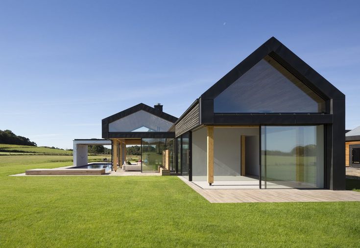 two modern houses in the middle of a grassy field