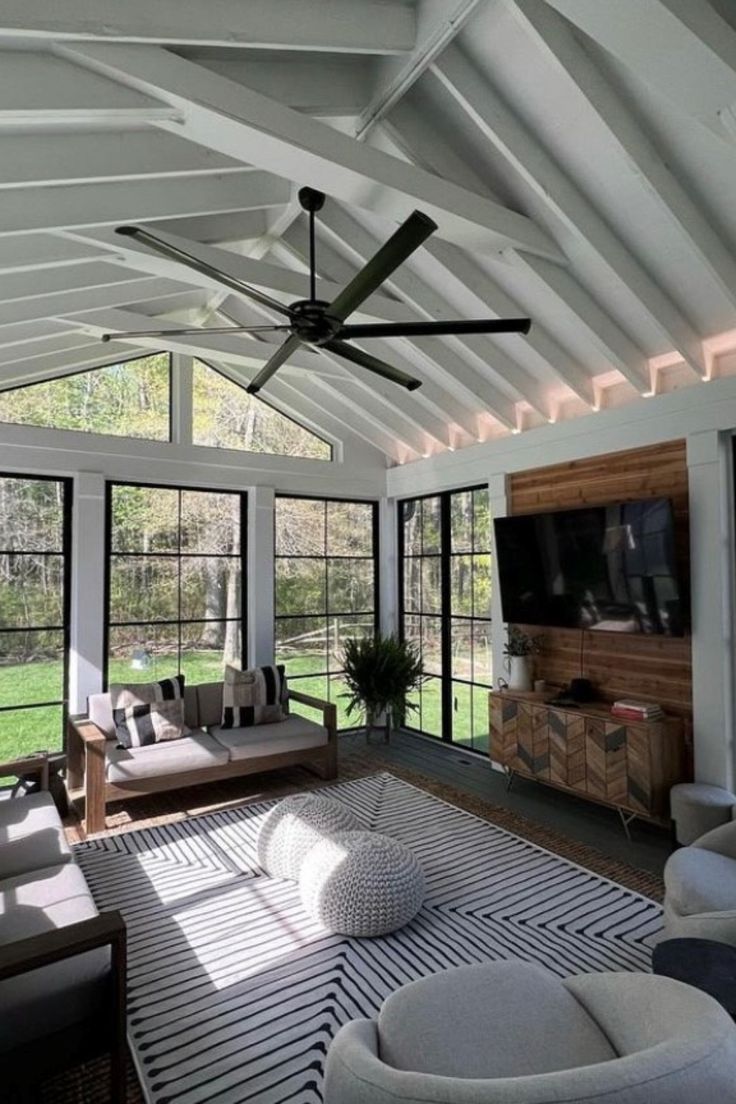 a living room filled with furniture and windows covered in white coverings on the ceiling