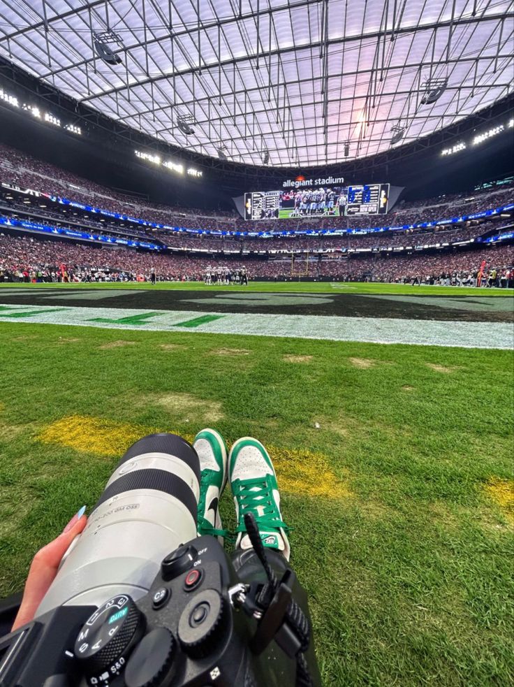 a person taking a photo with their camera at a football game in an empty stadium