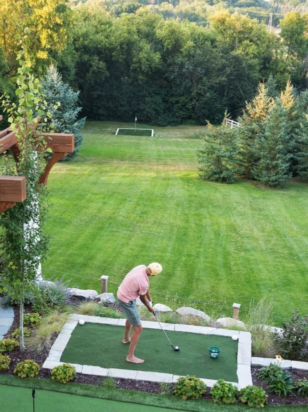 a man playing mini golf in his backyard