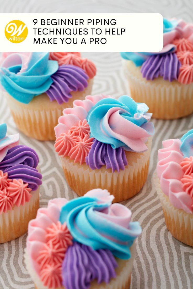 cupcakes decorated with pink, blue and purple frosting on a tablecloth