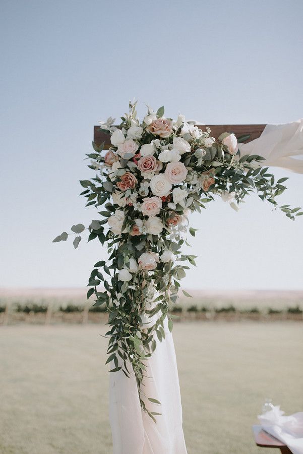 a wedding arch decorated with flowers and greenery