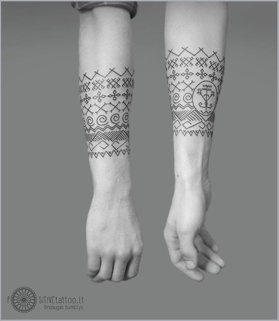 two people with tattoos on their arms and legs, one is holding the other's hand