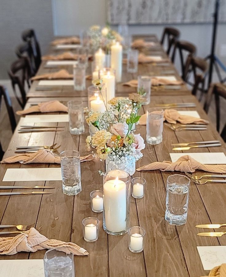 a long table is set with candles and place settings for an elegant dinner or party