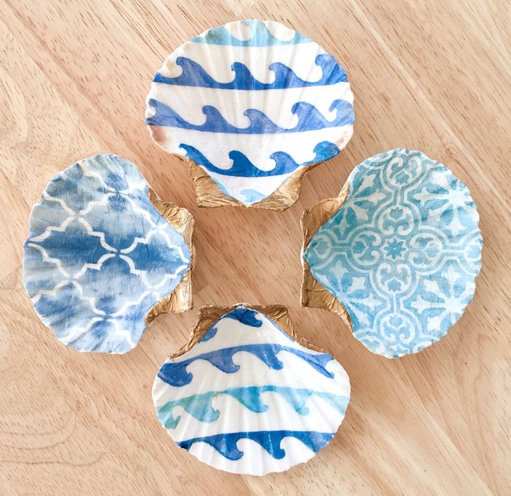 four blue and white plates sitting on top of a wooden table