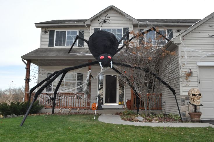 a large spider statue in front of a house