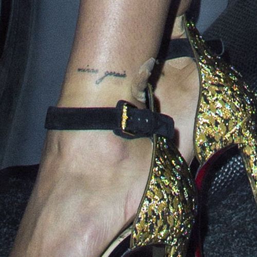 a close up of a person's foot wearing high heels with tattoos on them