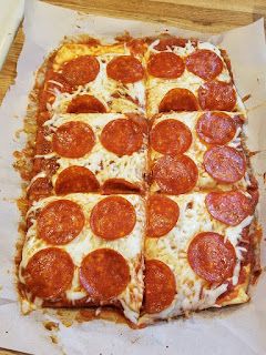 two slices of pepperoni pizza sitting on top of parchment paper