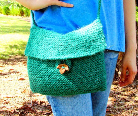 a woman holding a green crocheted purse