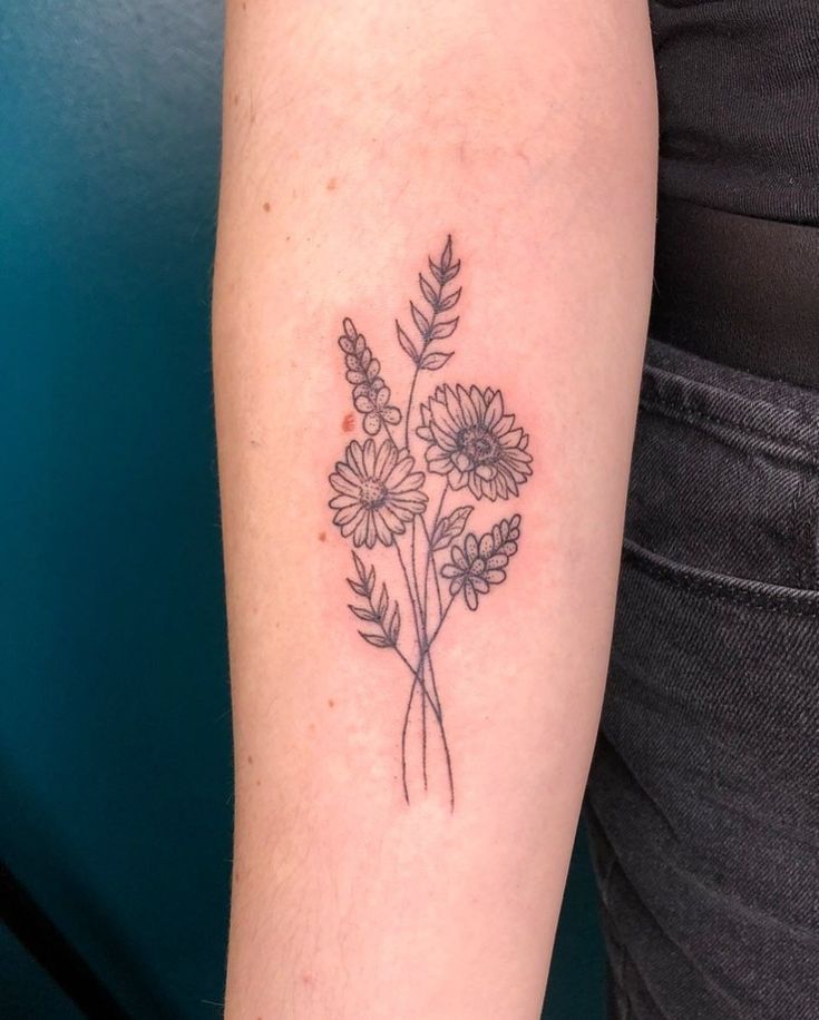 a woman with a flower tattoo on her arm