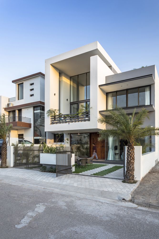 two story white house with palm trees in front