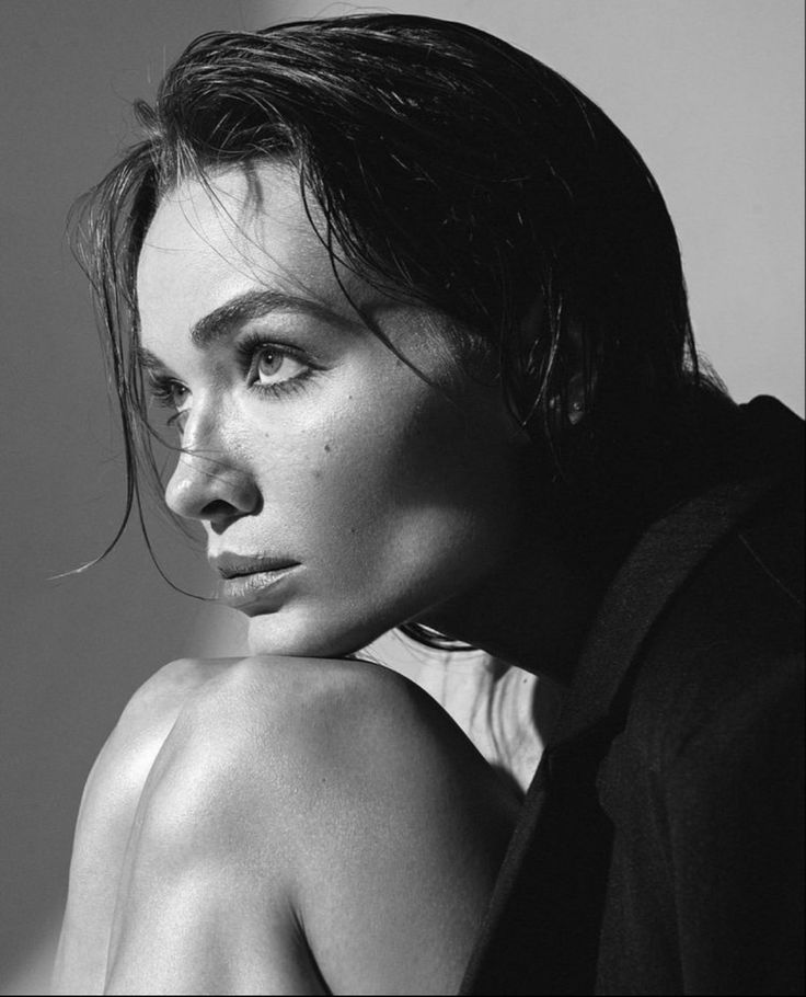 a black and white photo of a woman posing for a magazine cover shoot with her hair blowing in the wind